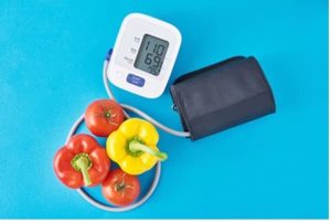 Blood pressure monitor displayed alongside vegetables.